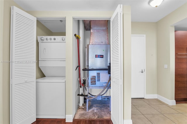 clothes washing area with light tile patterned floors and stacked washer / drying machine