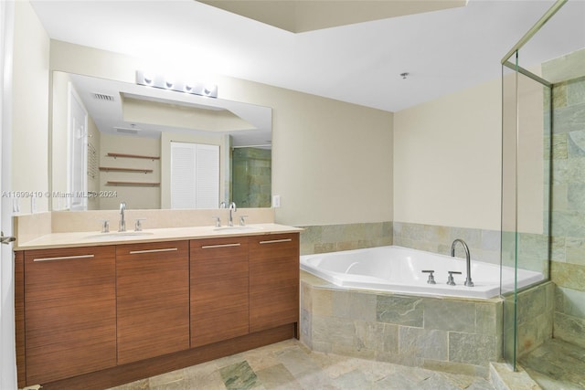 bathroom with vanity and shower with separate bathtub