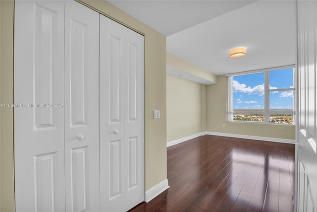 unfurnished bedroom featuring dark hardwood / wood-style flooring and a closet