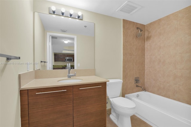 full bathroom featuring vanity, tile patterned floors, tiled shower / bath combo, and toilet