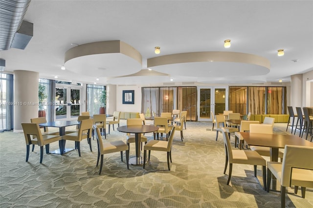 carpeted dining space featuring french doors