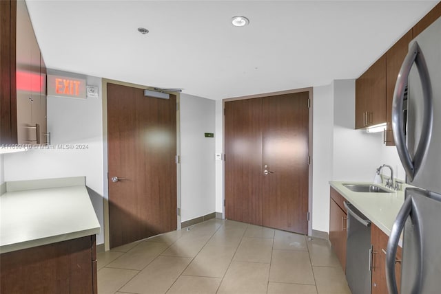 kitchen featuring light tile patterned flooring, sink, and stainless steel appliances