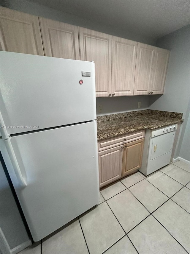 kitchen with white fridge, light tile patterned floors, and washer / clothes dryer