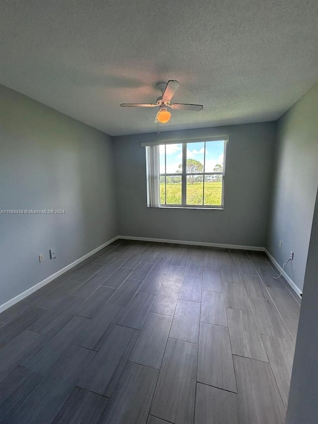 empty room with hardwood / wood-style floors, ceiling fan, and a textured ceiling