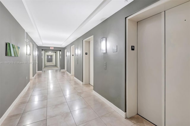 hall with light tile patterned flooring and elevator