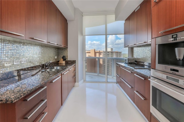 kitchen featuring dark stone countertops, decorative backsplash, sink, and stainless steel double oven