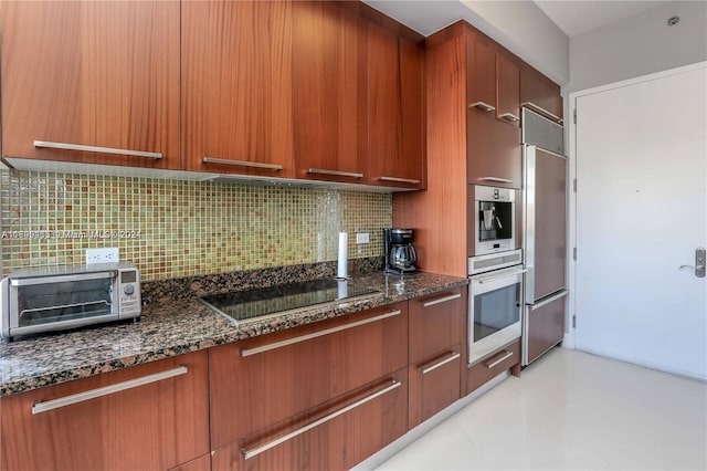 kitchen featuring backsplash, dark stone countertops, and appliances with stainless steel finishes