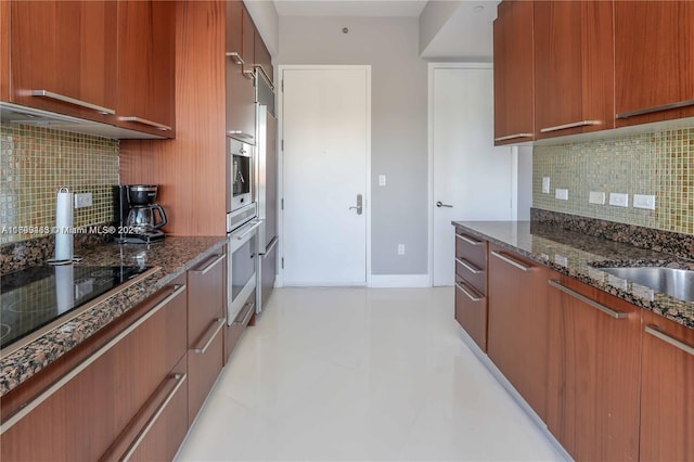 kitchen with tasteful backsplash, sink, dark stone counters, and stainless steel appliances