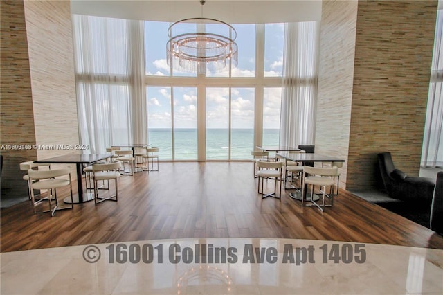 dining room featuring a water view, a healthy amount of sunlight, and hardwood / wood-style flooring