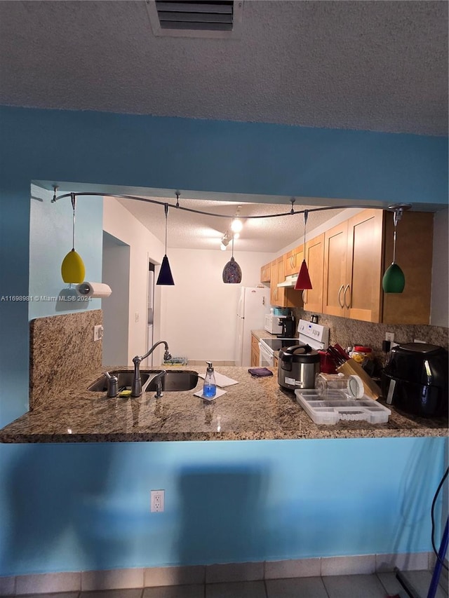 kitchen with backsplash, a textured ceiling, white appliances, sink, and hanging light fixtures