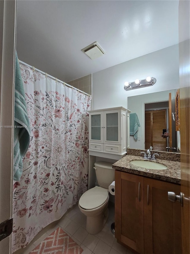 bathroom with toilet, vanity, tile patterned floors, and curtained shower