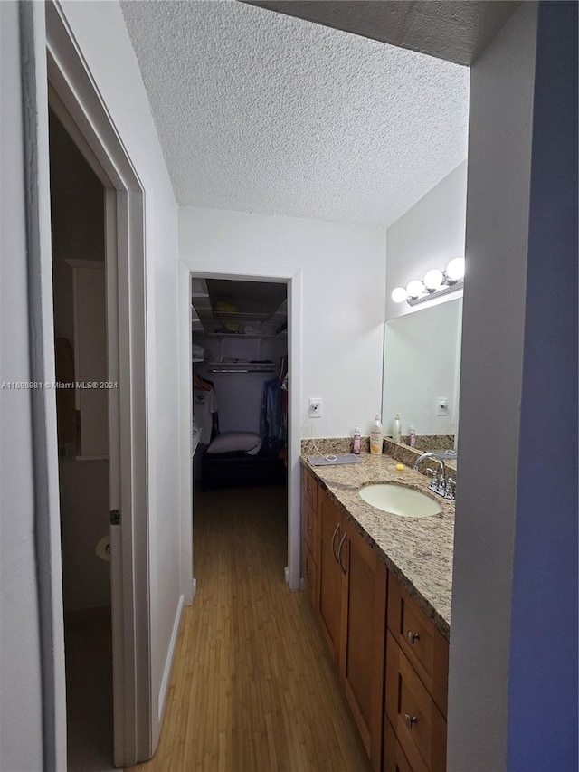 bathroom with vanity, wood-type flooring, and a textured ceiling