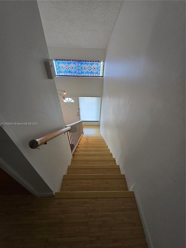 stairway with hardwood / wood-style floors