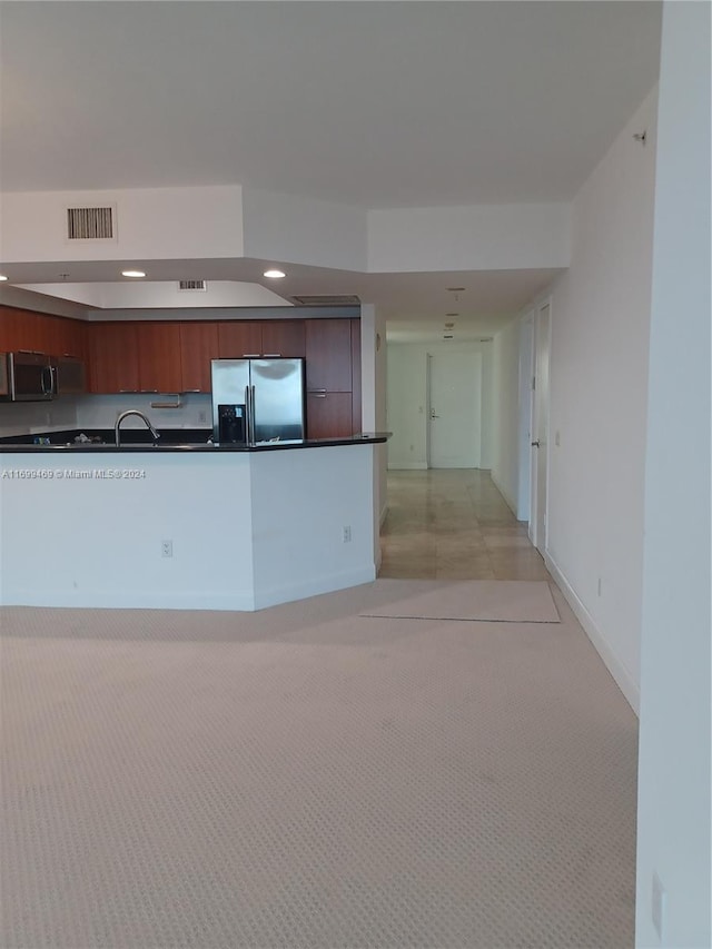 kitchen with sink, light colored carpet, and stainless steel appliances