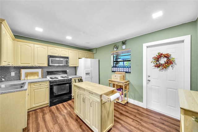 kitchen with black gas range, dark hardwood / wood-style flooring, white refrigerator with ice dispenser, and sink