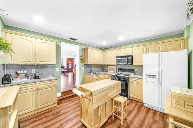 kitchen with white refrigerator with ice dispenser, black gas range, dark wood-type flooring, and sink