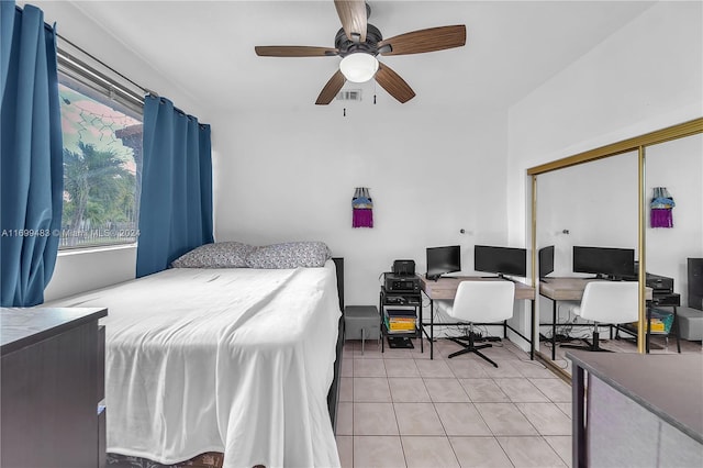 bedroom with ceiling fan, light tile patterned floors, and a closet