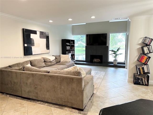 living room featuring a healthy amount of sunlight, light tile patterned flooring, and crown molding