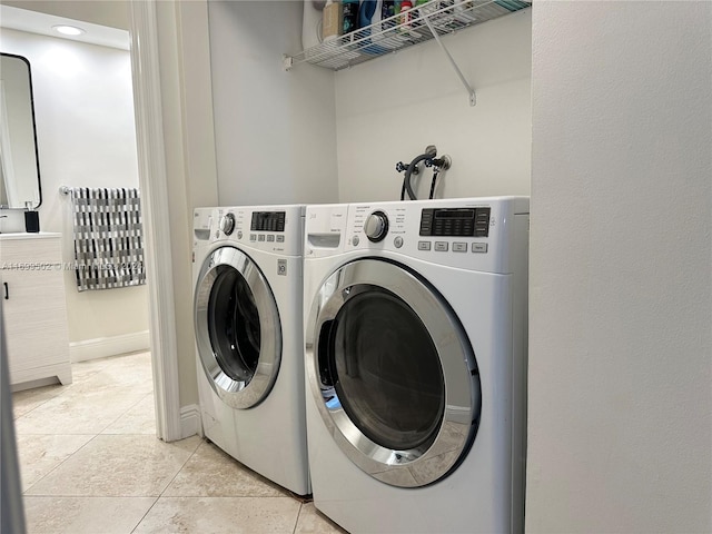 laundry room featuring washer and dryer and light tile patterned floors