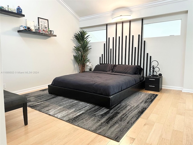 bedroom with hardwood / wood-style floors and ornamental molding