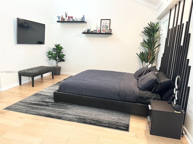 bedroom with hardwood / wood-style flooring and crown molding