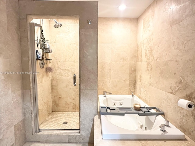 bathroom with separate shower and tub and tile walls