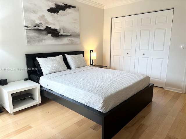 bedroom with light hardwood / wood-style floors, a closet, and crown molding