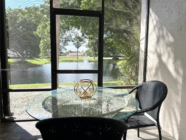 sunroom / solarium featuring a water view