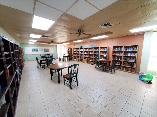 dining space featuring ceiling fan, a drop ceiling, and light tile patterned floors