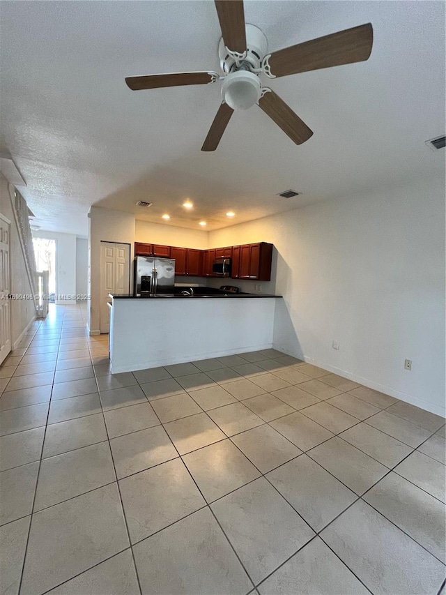 kitchen featuring stainless steel appliances, kitchen peninsula, and light tile patterned floors