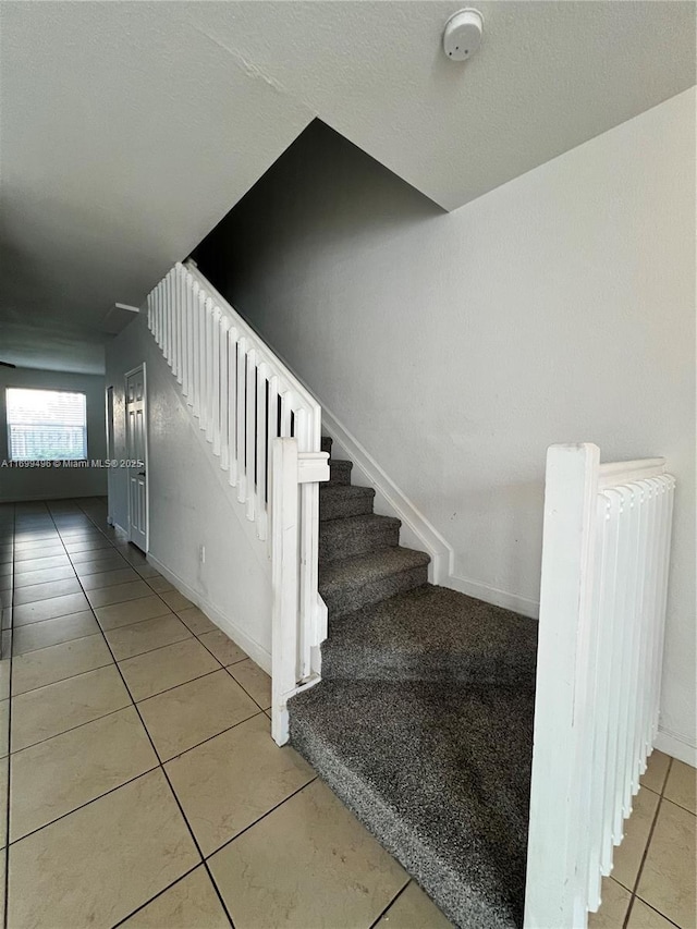 stairway with radiator and tile patterned floors