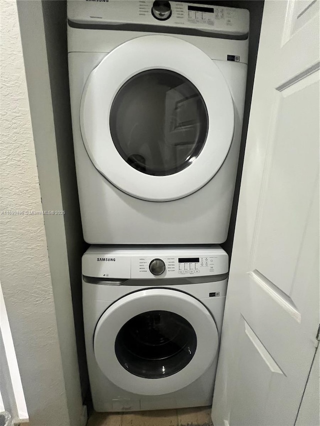 washroom featuring stacked washer and clothes dryer