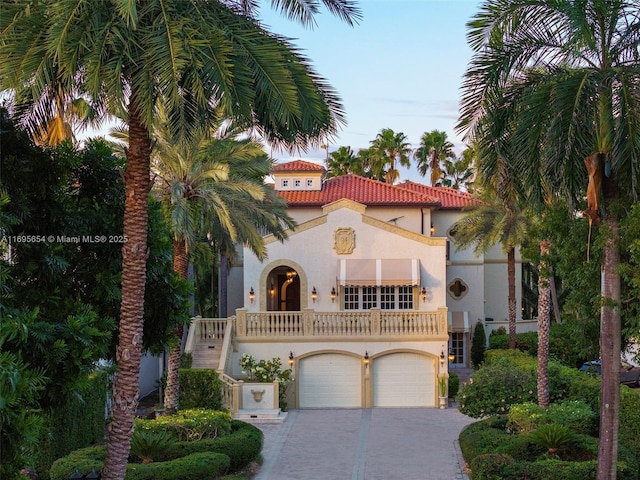 mediterranean / spanish home with a garage and a balcony