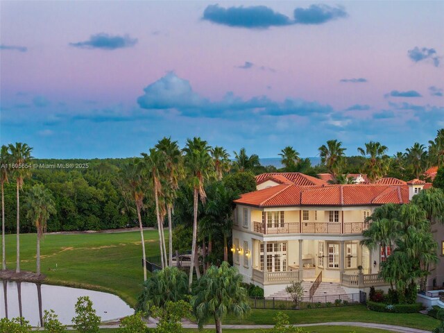 back house at dusk with a balcony