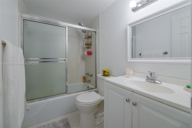 full bathroom featuring tile patterned floors, toilet, vanity, and combined bath / shower with glass door