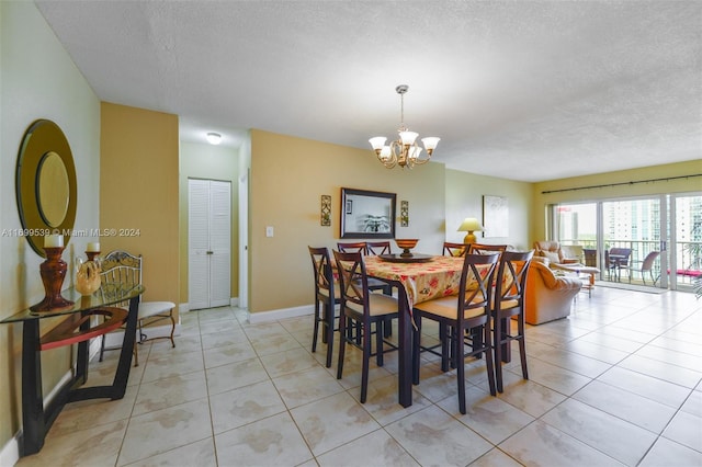 dining space with light tile patterned floors, a textured ceiling, and an inviting chandelier