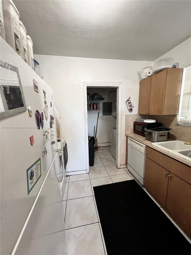 kitchen featuring dishwasher, light tile patterned floors, and sink