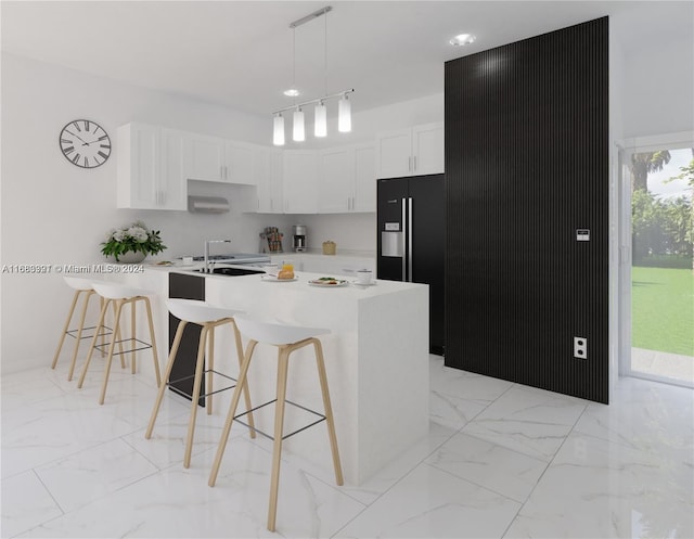 kitchen with rail lighting, a breakfast bar, decorative light fixtures, white cabinetry, and an island with sink