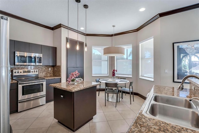 kitchen featuring appliances with stainless steel finishes, a center island, pendant lighting, and sink