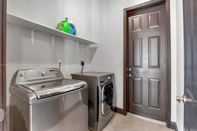 laundry room with light tile patterned floors and washing machine and dryer