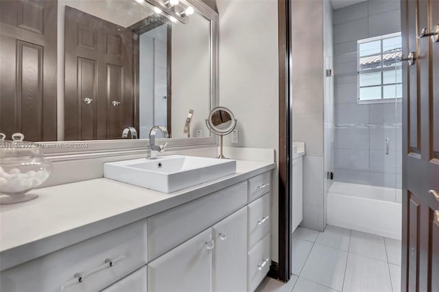 bathroom with tile patterned flooring, vanity, and tiled shower / bath combo