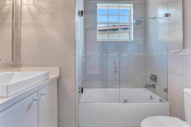 full bathroom featuring shower / bath combination with glass door, vanity, and toilet