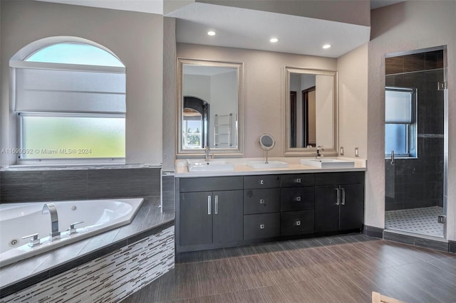 bathroom with wood-type flooring, vanity, separate shower and tub, and a healthy amount of sunlight