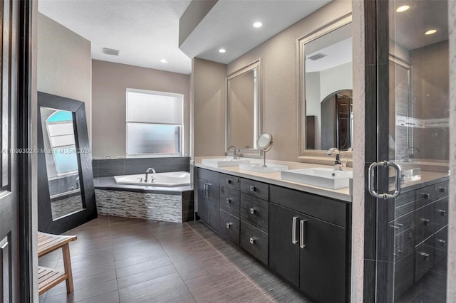 bathroom featuring vanity, plus walk in shower, wood-type flooring, and a textured ceiling