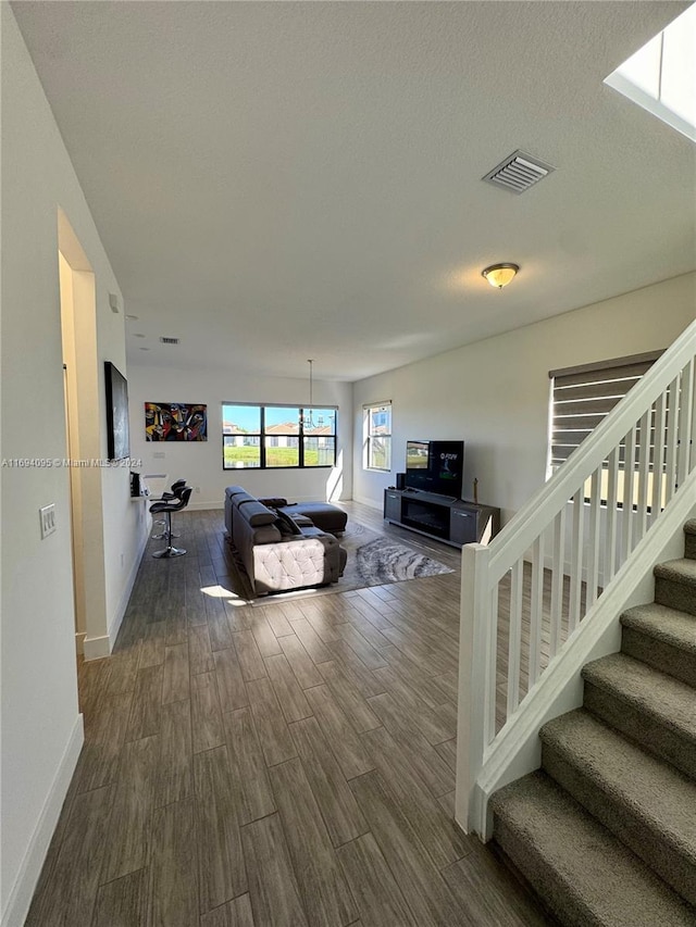 living room with a textured ceiling and dark wood-type flooring