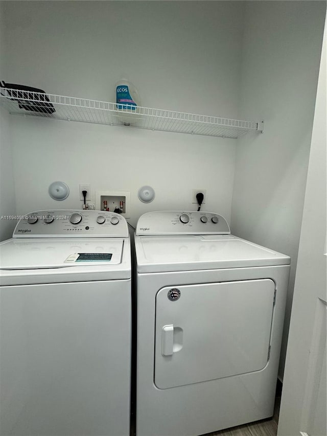 clothes washing area with light wood-type flooring and independent washer and dryer