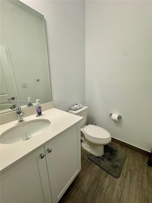 bathroom featuring vanity, toilet, and wood-type flooring