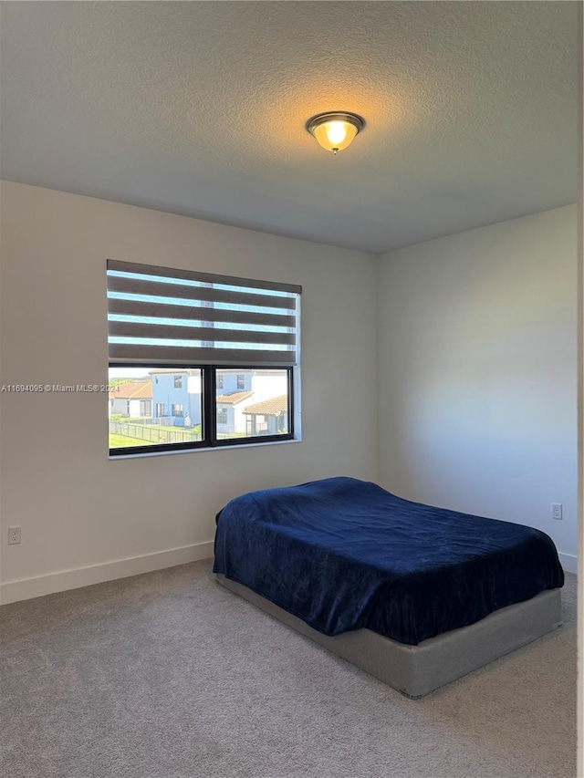 bedroom with carpet flooring and a textured ceiling