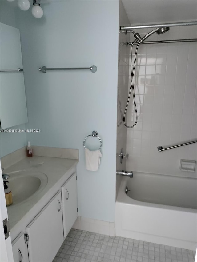 bathroom with tile patterned floors, vanity, and tiled shower / bath