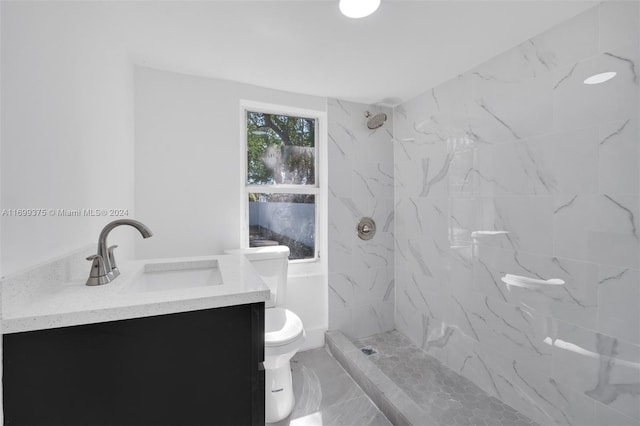 bathroom featuring tiled shower, vanity, and toilet